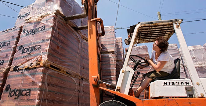 Amira Abi Khalil opera una carretilla elevadora para mover paletas de baldosas. Desde 1997 es propietaria y operadora de su empresa comercializadora de ladrillos y piedras en el Líbano. ONU Mujeres adquiere productos y servicios de empresas de mujeres como la suya. Foto: ONU Mujeres/Joe Saade.